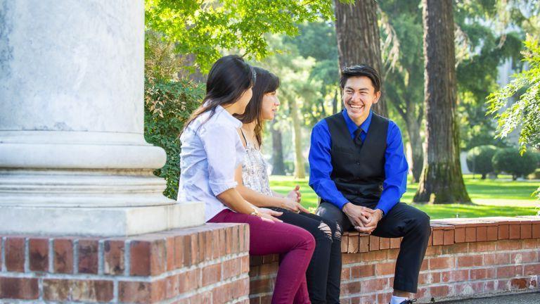 Success TRiO student sitting at columns on campus